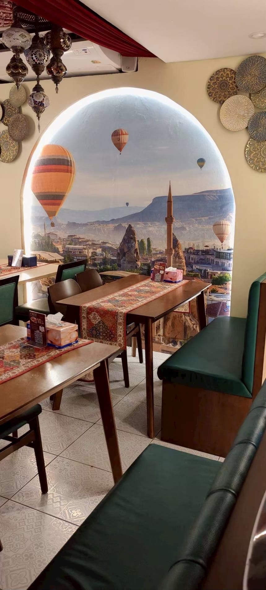 Hot air balloon landscape mural framed as an arch in a restaurant dining room