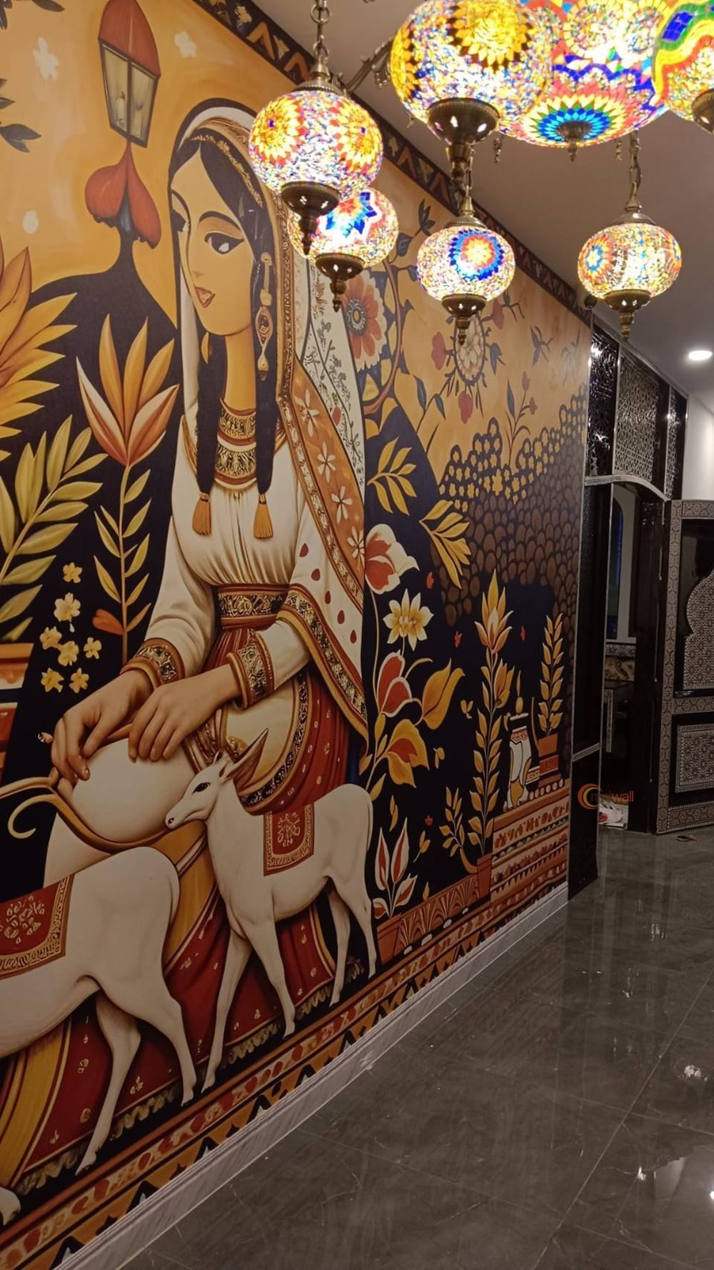 Folk-art figure mural in a restaurant hallway under mosaic lamps