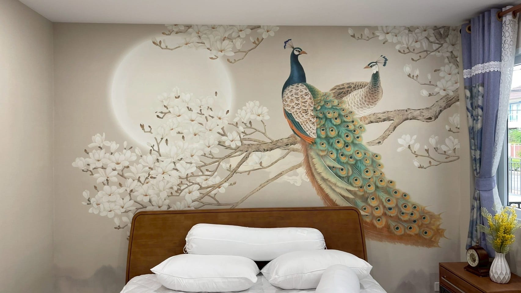 Peacock and magnolia mural on the headboard wall of a bedroom