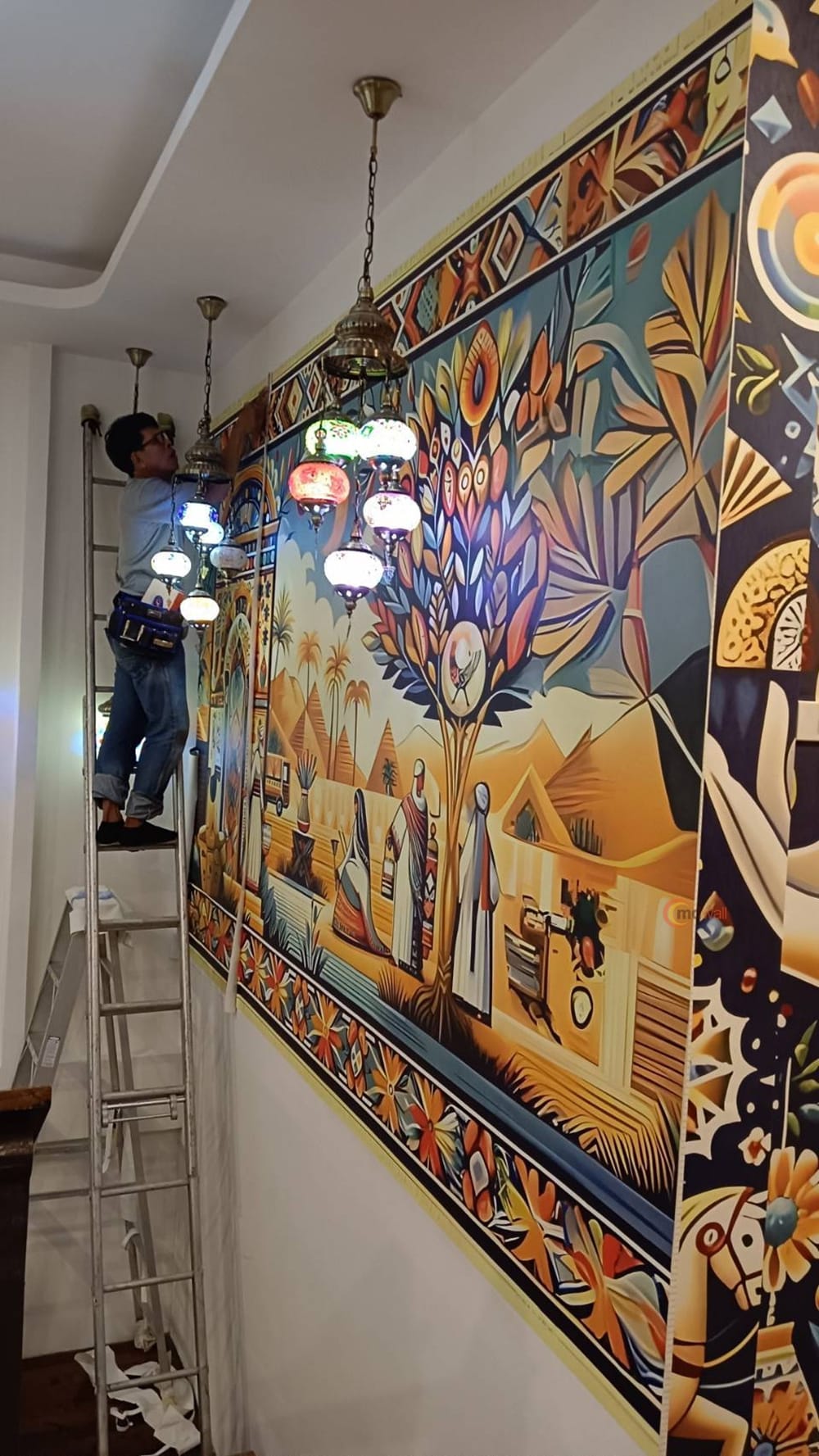 Fitting a large restaurant mural panel by panel from a ladder