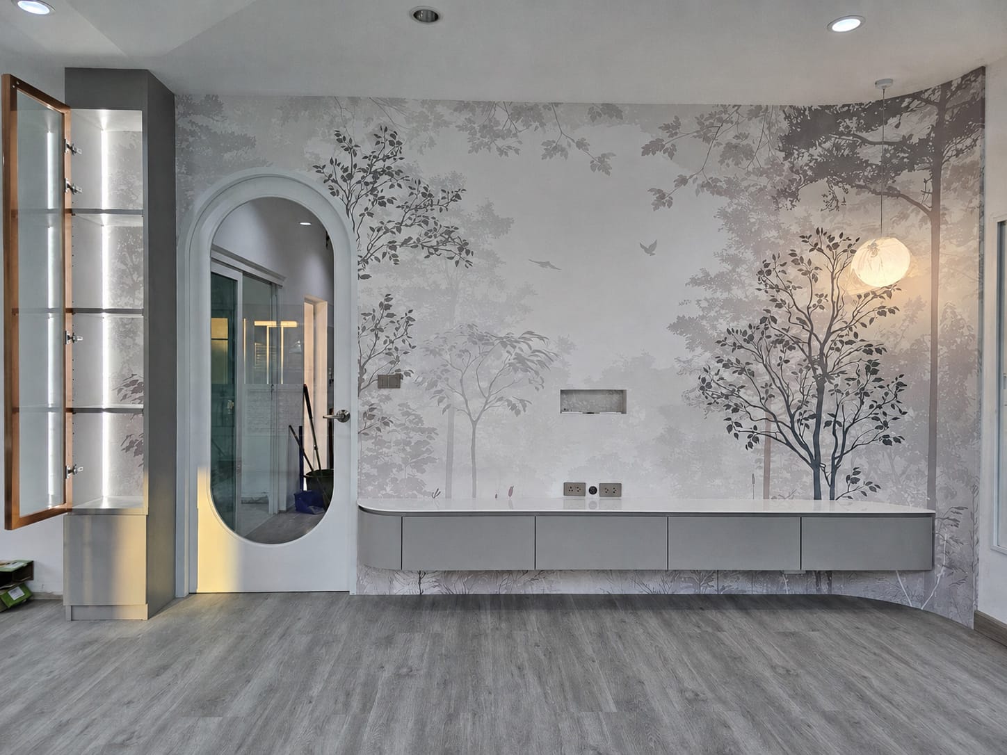 Misty grey forest mural along a living room wall with a floating cabinet